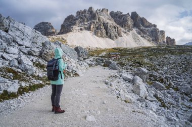 Sırt çantalı bir kadın Tre Cime Ulusal Parkı 'nda yürüyüş yapıyor. Dolomitler, İtalya, Avrupa.