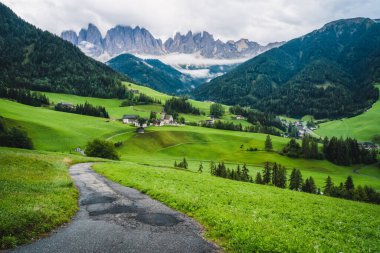Val di Funes Vadisi, Dolomites, İtalya 'daki St. Magdalena Kilisesi' ne yürüyüş yolu. Arkaplanda Furchetta ve Sass Rigais dağ zirveleri.