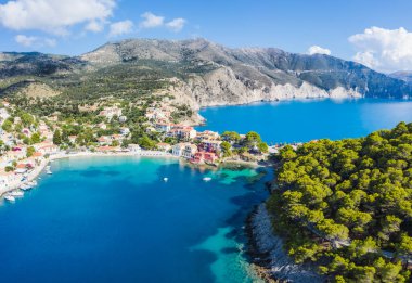Assos, Yunanistan 'ın Kefalonia kentinin yukarısından güzel bir balıkçı köyü. Erial drone görüntüsü. Yelkenli tekneler turkuaz körfezde demirlemiş..