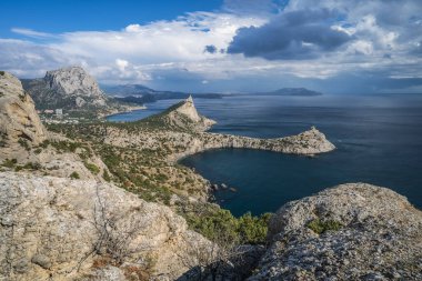 Falcon Dağı, sonbahar sezonunda Novyi Svit 'te pembe gün batımıyla aydınlanır. Sudak, Kırım Cumhuriyeti. Hava görünümü.