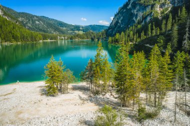 Pragser Wildsee 'de hava manzarası, Güney Tyrolean Dolomitleri' nde bir göl. Gölün etrafındaki yüksek dağ zincirleri. Gökyüzü ve dağlar göle yansıyor..