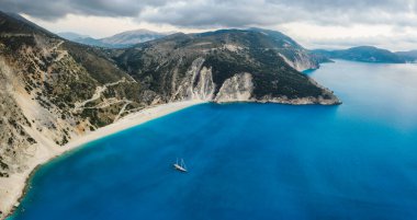 Yunanistan 'ın Kefalonia Adası' ndaki mavi körfezli Myrtos sahilinde lüks bir yat. Havadan panoramik fotoğraf.