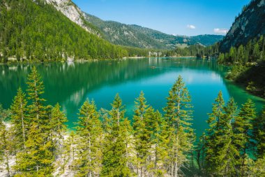 Pragser Wildsee 'de hava manzarası, Güney Tyrolean Dolomitleri' nde bir göl. Gölün etrafındaki yüksek dağ zincirleri. Gökyüzü ve dağlar göle yansıyor..