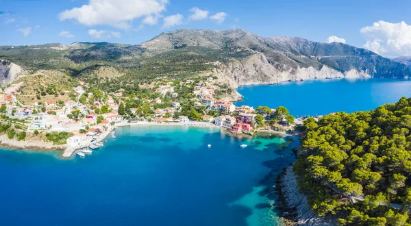 Assos, Yunanistan 'ın Kefalonia kentinin yukarısından güzel bir balıkçı köyü. Erial drone görüntüsü. Yelkenli tekneler turkuaz körfezde demirlemiş..