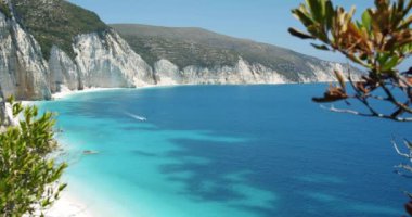 Yunanistan 'ın Keflaonia Adası' ndaki güzel Fteri plajı. Yeşil yapraklarla çevrili beyaz kayalar ve mavi göl.