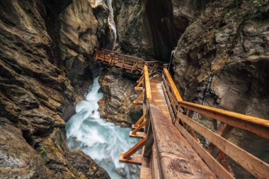 Bue dağ nehri ile kaplı bir vadi içinde tahta yürüyüş yolu, Sigmund Thun Klamm, Kaprun, Avusturya.