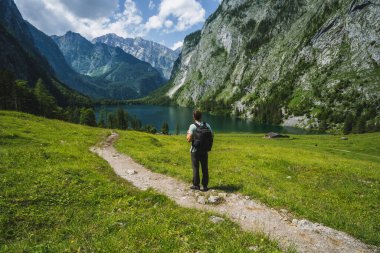 Sırt çantalı bir adam yürüyüş yolunda Hinterer Gosausee ve Salzkammergut 'un keyfini çıkarıyor. Avusturya.