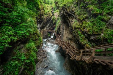 Bue dağ nehri ile kaplı bir vadi içinde tahta yürüyüş yolu, Sigmund Thun Klamm, Kaprun, Avusturya.