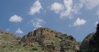 Adeje, Tenerife yakınlarındaki Barranco del Infino 'nun kayalık dağlık manzarası yürüyüş yolunu gösteriyor..