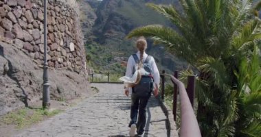 Masca Vadisi ve Tenerife köyü. Sırt çantalı güzel genç bayan turist mekanı ziyaret ediyor. Yavaş çekim
