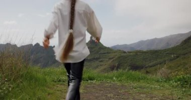 Masca Vadisi, Tenerife. Güzel genç bayan turist kollarını kaldırarak manzara manzarasının tadını çıkarıyor..