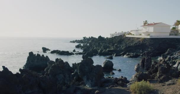 背後の岩場の海岸で はっきりとした紺碧の大西洋 日没と火山岩の海岸線 旅行や休息のための完璧な場所 終わりのない自然の美しさ — ストック動画