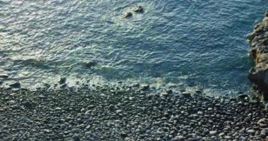 Huzurlu okyanus manzarası, siyah taşlı kayalık volkanik plaj, Tenerife. Gün batımı. Hiç kimse. Deniz kıyısının sakin, vahşi manzarası. Kanarya Adaları, İspanya, Avrupa.