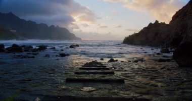 Playa de Benijo, beach in the north of Tenerife, in background mountain ranges of Anaga National Park. Canary Islands, Spain. Steps go into the water, Atlantic Ocean. Spectacular view on stormy waves.