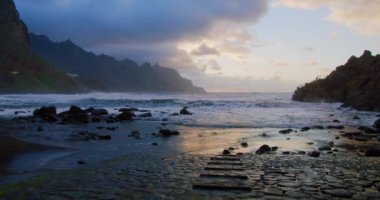Beautiful sunset light and sunbeams at Benijo Beach in Tenerife, Canary Islands, Spain. Steps go into the water, ocean. Cinematic colorful view on Playa de Benijo.