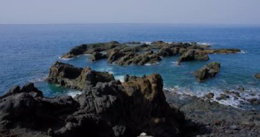 Wilderness outdoor beach along the volcanic rocky coastline on Tenerife, Spain, Canary islands, Europe. Ocean waves crashing on rocky coast seashore beach, nobody.