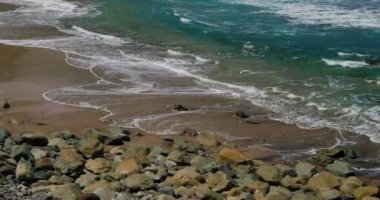 Black sand volcanic rocky beach with huge waves at Tenerife. Cinematic seascape. Beautiful wild nature, foaming waves hit rocky shore. Nobody.