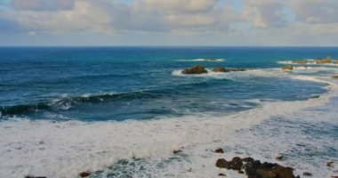 Colorful sea beach, waves foaming and splashing on the rocky shoreline. Ocean waves in open sea at Tenerife north, Anaga Natural Park. Nobody.