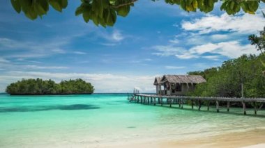 Bambu kulübe Gam Adası, Batı Papua, Raja Ampat, Endonezya ahşap hisse senedi bir aile yanında konaklama, önünde sakin temiz su ile mavi lagune.