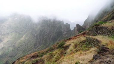 Dağ zirvelerinin kenarlarından sis akıyor. Xo-Xo Vadisi 'ndeki inanılmaz dağ manzarası. Santo Antao Adası, Cape Verde Cabo Verde 4k video. Pan