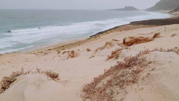 Witte Zandduinen Vulkanische Rotsen Oceaangolven Spatten Langzaam Tegen Het Strand — Stockvideo