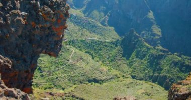 Beautiful view of the Masca Gorge or Barranco de Maska from the peak of the mountain peak. Rocky mountains in the foreground. Mirador La Cruz de Hilda. Nobody. Hand held.