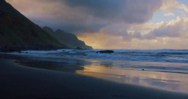 Dramatic sea sunrise. Burning sky and shining golden waves. Reflection of sunset light on the ocean. Tenerife north.