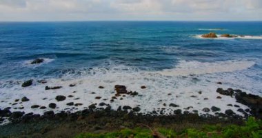 Colorful sea beach, waves foaming and splashing on the rocky shoreline. Ocean waves in open sea at Tenerife north, Anaga Natural Park. Nobody.