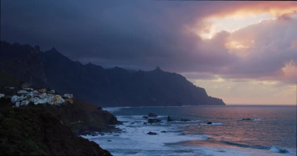 海の岩の上に沈む夕日 背後に泡と巨大な火山の形成を持つ大西洋の波 テネリフェ島の北 カナリア諸島 ロック アナガ — ストック動画