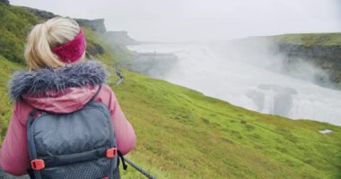 Gullfoss Şelalesi 'ne bakan turist kadın. İzlanda' nın en ünlü eğlence ve dönüm noktası.