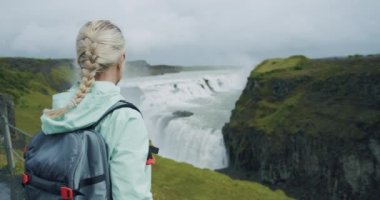 Şelale Gulfoss ve turist kadın. Altın Çember Adası 'nın ünlü İzlanda cazibesi ve dönüm noktası.
