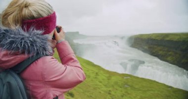 Gullfoss Şelalesi 'ne bakan turist kadın. İzlanda' nın en ünlü eğlence ve dönüm noktası..