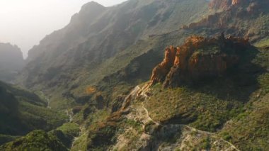 Batan güneşin ışığında inanılmaz güzel, keskin uçurumlar. Kayaların sırtları baharda yeşil bitki örtüsünün üzerinde yükselir. Dağ Risco Blanco. Her yere gidin. Tenerife, Kanarya Adaları, İspanya