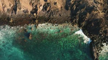 Uçağı Tenerife Cennet Adası 'ndaki yaban kayalıkları üzerinden uçuracak. Dalgalar taşların ve kayaların üzerinde kırılıyor. Su zümrüttür, koyu mavi ve yeşil. Turkuaz Atlantik Okyanusu 'nun güzel manzarası