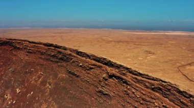 Krater sırtı boyunca koşan kadın sporcu. Fuerteventura, Kanarya Adası, İspanya 'daki Calderon Hondo volkanını muhteşem bir şekilde korudu. Turistik bir yer. Volkanik ıssız bölge. Kuru Temizle