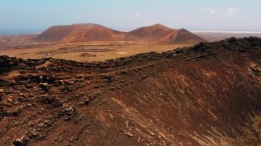 Krater sırtı boyunca koşan kadın sporcu. Fuerteventura, Kanarya Adası, İspanya 'daki Calderon Hondo volkanını muhteşem bir şekilde korudu. Turistik bir yer. Volkanik ıssız bölge. Kuru Temizle