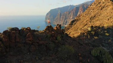 Kadınlar dağlarda doğa manzarasının tadını çıkarırlar. Uçurumun zirveleri. Tenerife, Kanaryalar, İspanya. Ağaççılar rüya görür. Yürüyüş. Derin mavi okyanus plajı. Gerçek insanlar. COVID zamanında seyahat ediyormuş. İHA