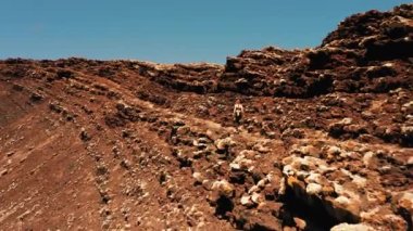 Kadın gezgin Calderon Hondo yanardağının lav kraterinde koşuyor. Fuerteventura, Kanarya Adası, İspanya. Her yere gidin. Başka bir gezegenin yüzeyinde, terk edilmiş yabancı bir dünya. Sağlıklı yaşam tarzı