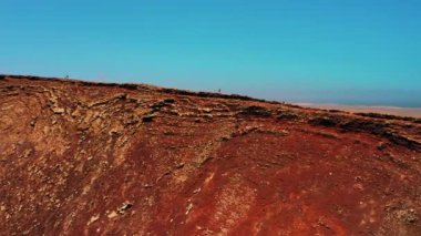 Tanınmayan turistler krater sırtı boyunca yürüyorlar. Fuerteventura, Kanarya Adası, İspanya 'daki Calderon Hondo volkanını muhteşem bir şekilde korudu. Turistik bir yer. Volkanik ıssız bölge. Boşalt