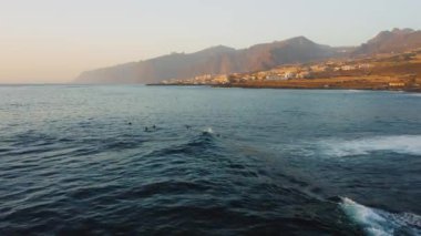 Muhteşem bir tatil beldesi olan Los Gigantes halk plajında yükselen sisli dağ silsilesiyle. Gün batımında Tenerife adasının kıyılarında esen güçlü rüzgarın yol açtığı azgın okyanus dalgaları.