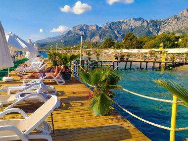 Arkasında Kemer, Goynuk, Türkiye 'de tatil beldesi rıhtımları ve dağlar bulunan deniz kıyısı
