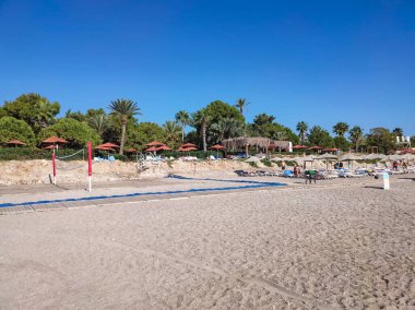 Tekirova, Antalya, Türkiye - 11 Mayıs 2021: Türkiye 'nin Kemer kentindeki Tekirova' da şemsiye ve şezlonglarla kumsaldaki güverte sandalyeleri
