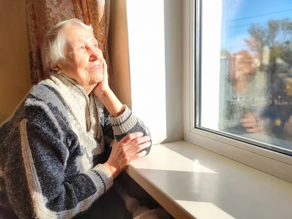 Wanita Tua Kesepian Duduk Dekat Jendela Rumahnya Dengan Bunga — Stok Foto