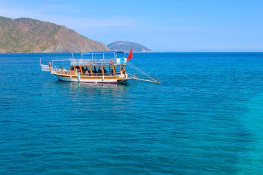 Akdeniz kıyısındaki Antalya ve Kemer yakınlarındaki Adrasan Koyu 'nun kıyısındaki yatta eğlenen insanlar.