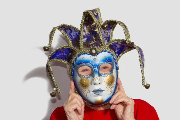 Senior vrouw met carnaval masker op haar gezicht — Stockfoto