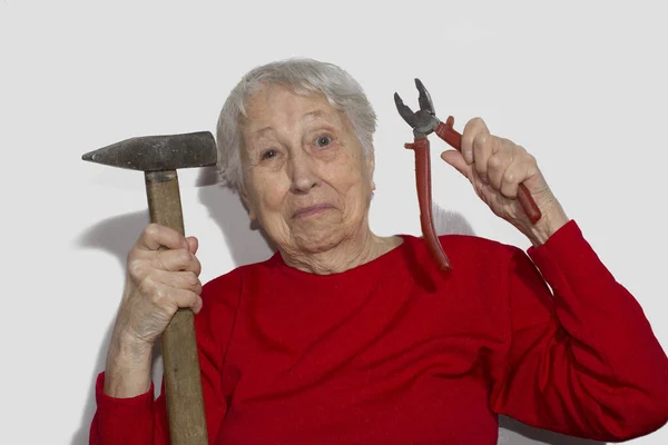 Retrato engraçado de mulher sênior segurando martelo e alicates em sua mão isolado em branco — Fotografia de Stock