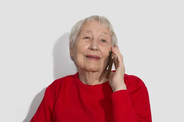 Mulher sênior falando no telefone interior — Fotografia de Stock