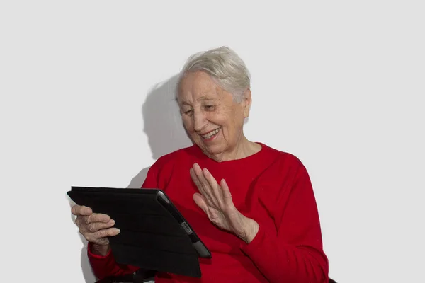 Mulher sênior sorridente com um computador tablet. Isolado sobre branco — Fotografia de Stock