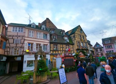 Colmar, Fransa - 30 Aralık 2021: Fransa 'nın Alsace bölgesindeki Colmar' da Noel süsleriyle sokağa çıkan insanlar.