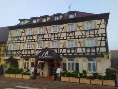 Eguisheim, Alsace, Fransa - 30 Aralık 2021: Fransa 'nın Alsace-şarap bölgesinde geleneksel bir köy olan Eguisheim' da eski bir bina, şimdi geleneksel bir ev, bir şarap degustation mekanı